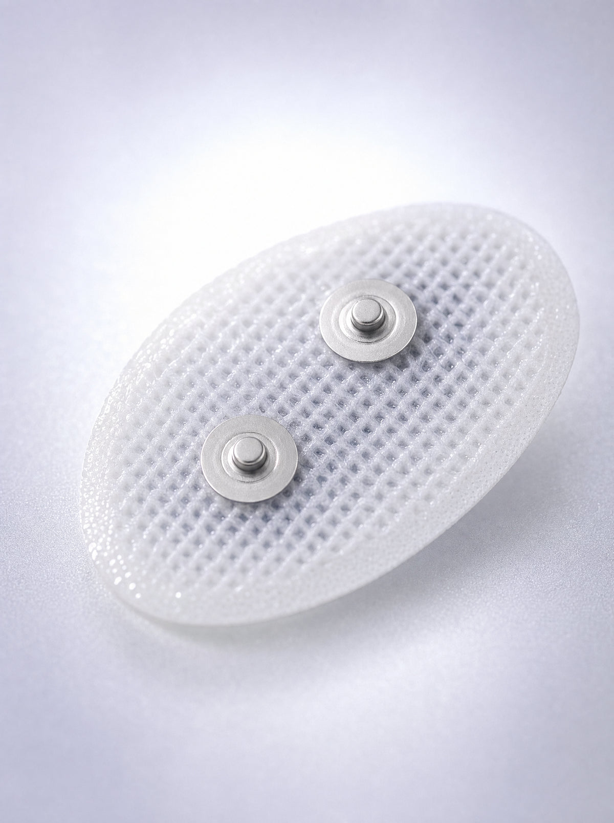 Macro of a FYROST Hush gel pad, showing the mesh face and twin snap studs