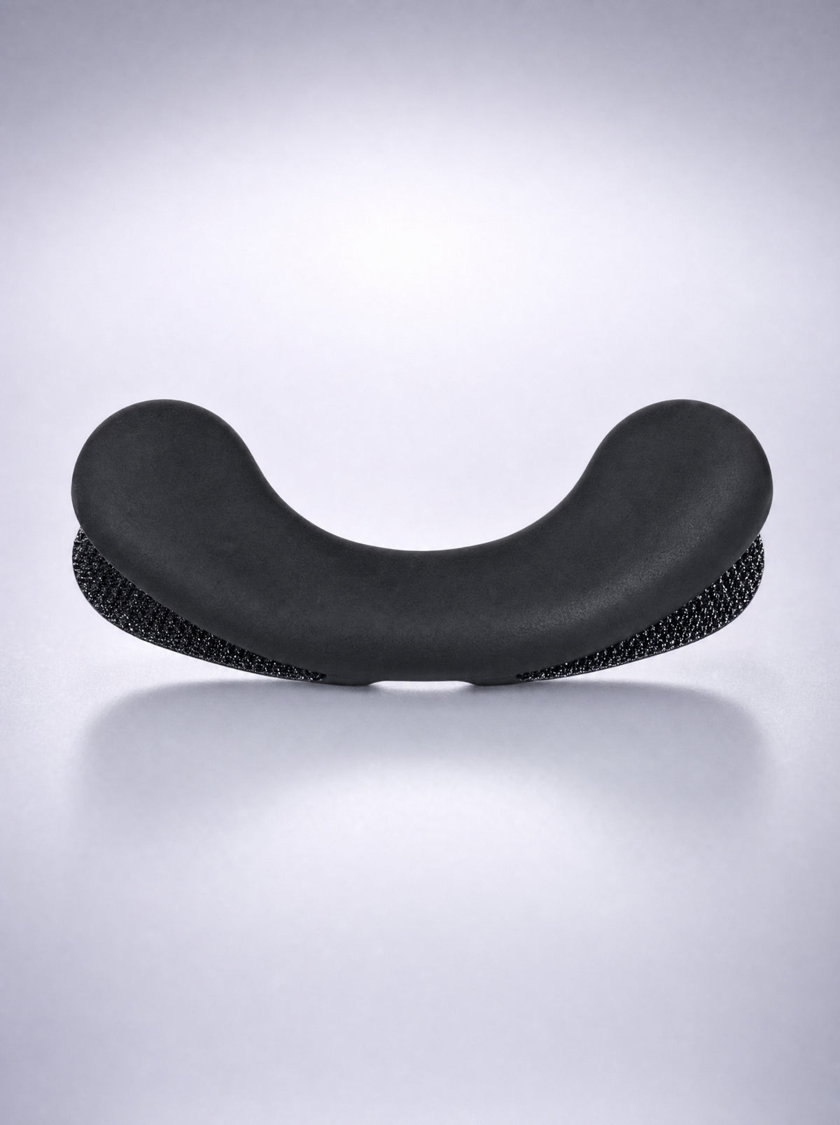 Close-up of a FYROST Zephyr silicone dilator, showing the smooth face and the textured backing