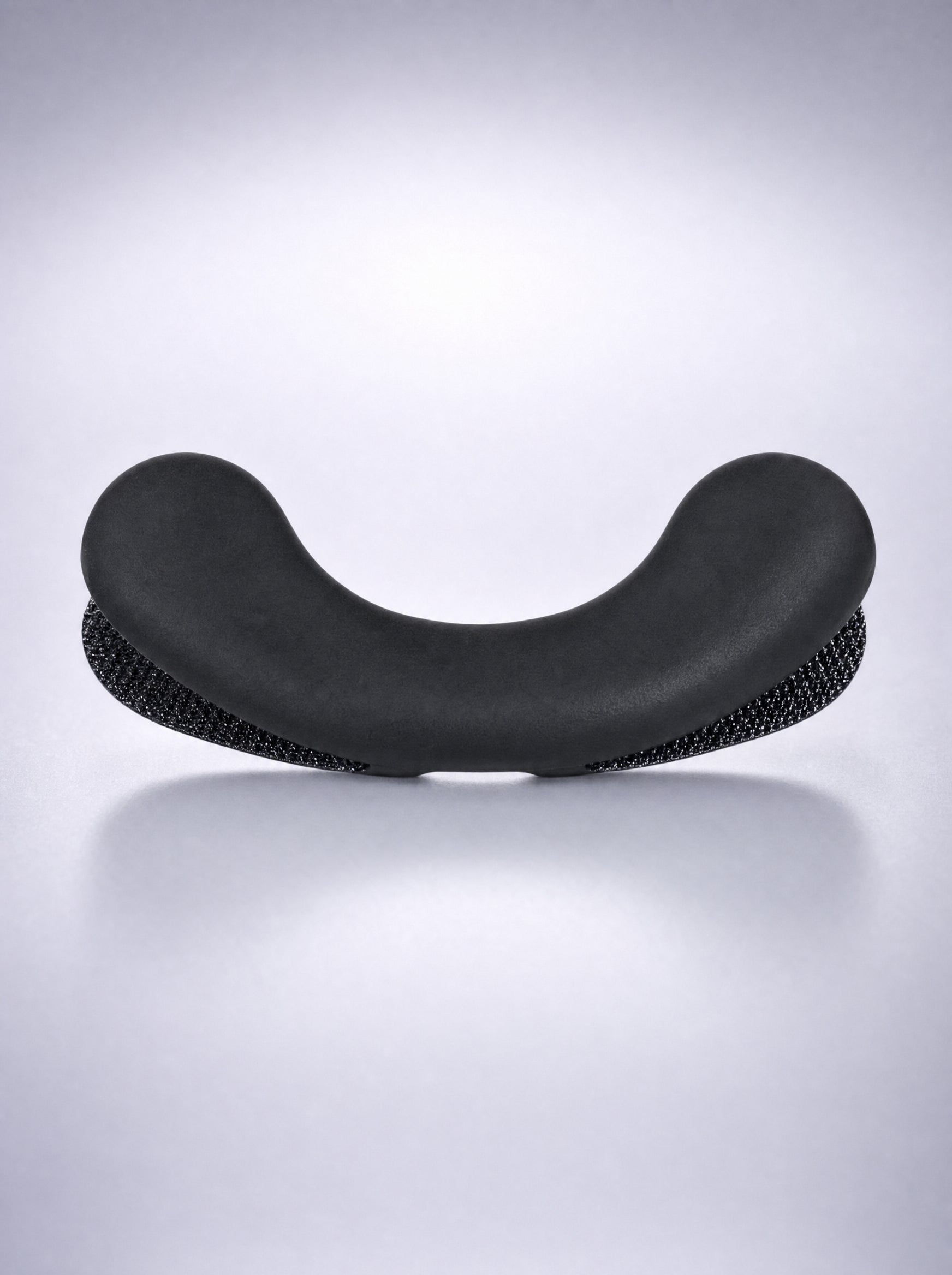 Close-up of a FYROST Zephyr silicone dilator, showing the smooth face and the textured backing